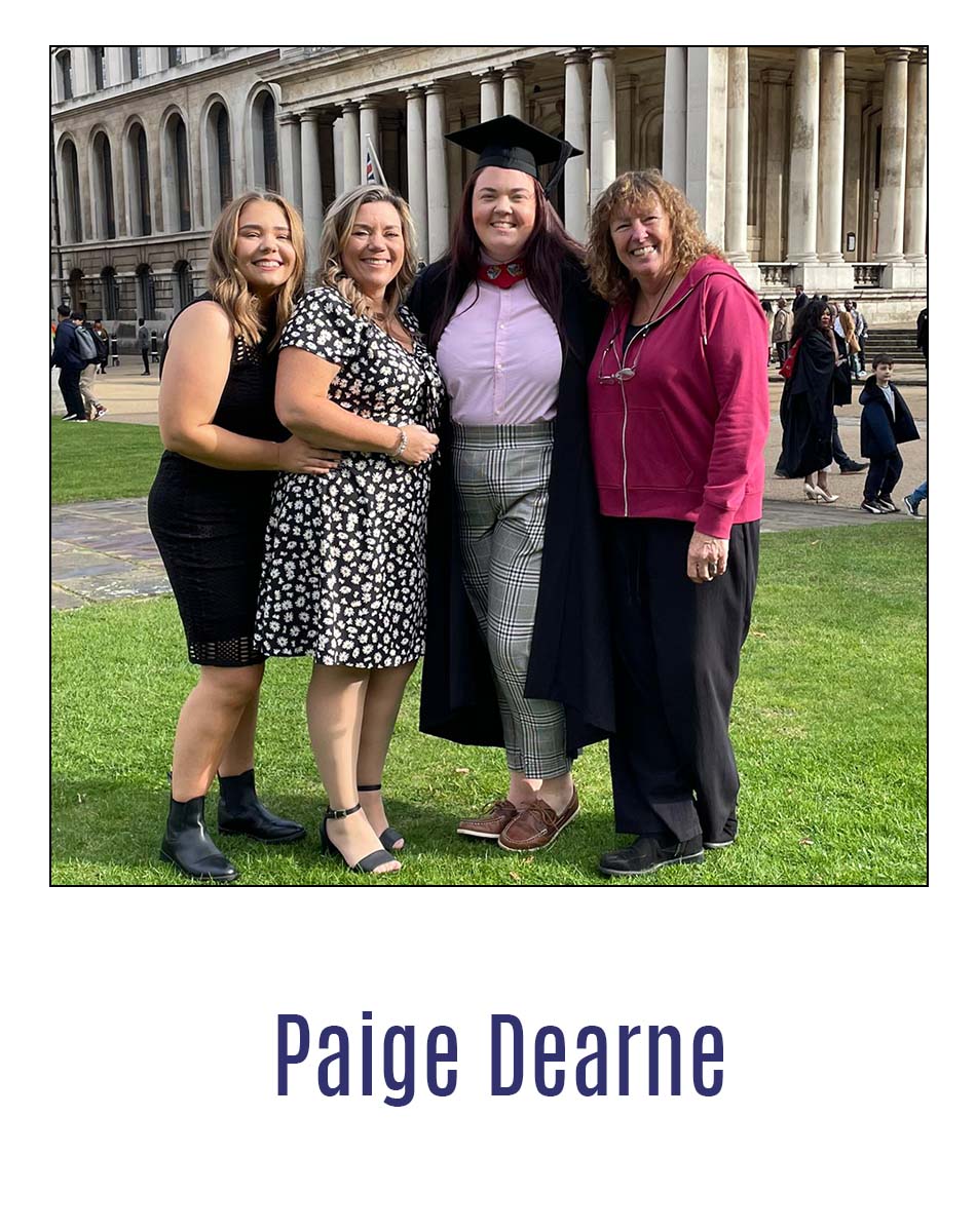 Alumnx Paige Dearne standing smiling with family dressed in graduation robes.